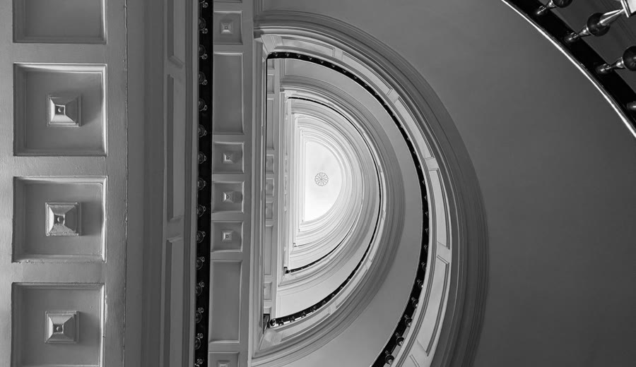A grand spiral staircase viewed from below, representing growth and progress